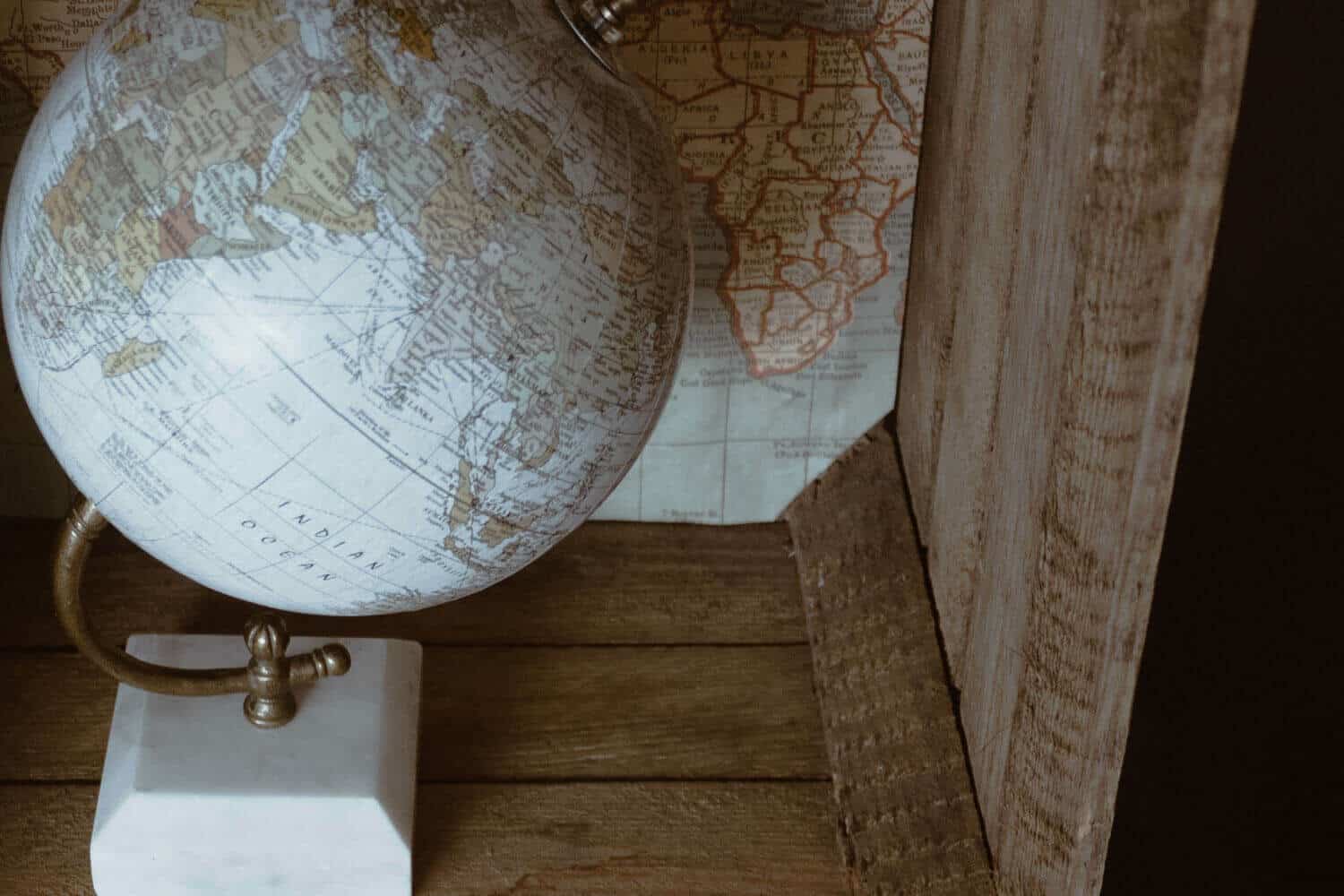 Kleiner Globus in einer Holzkiste mit Weltkarte